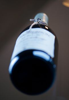 Red wine bottle with grapevine shallow depth field
