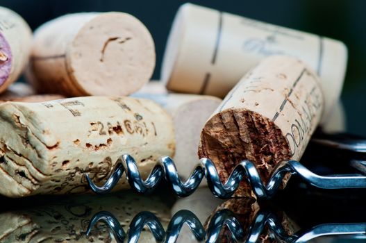 Corkscrew and corks on a glass table close up