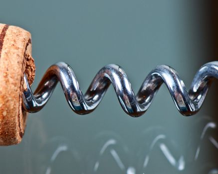 Corkscrew and cork on a glass table close up