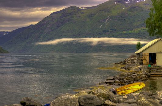 Geiranger fjord HDR yellow boat low clouds