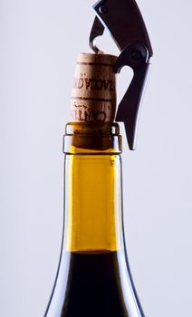 Corkscrew and wine stopper with a yellow bottle close up