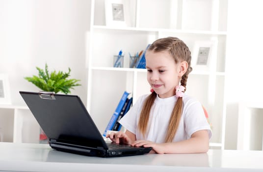 girl working on laptop at home, sitting at the table