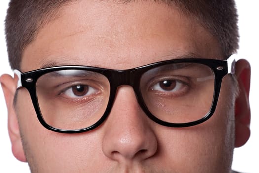 A young teenage man isolated over white wearing black frame nerd glasses and military style dog tags.