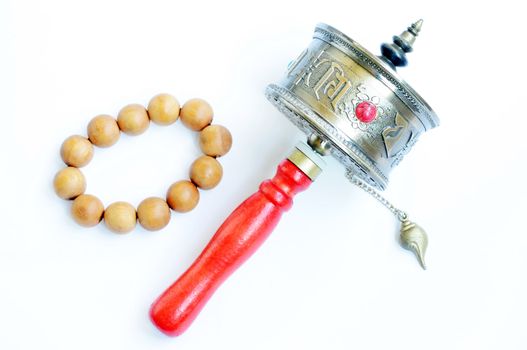 Tibetan prayer wheel and beads on a white background