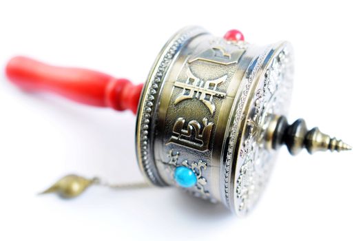 Closeup of a Tibetan prayer wheel on a white background