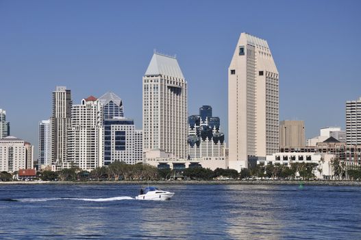 A speed boat moves across San Diego Bay in front of the downtown office towers.