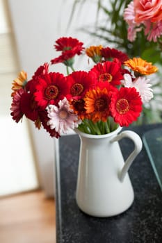 bouquet of gerberas in vase in the interior. Vertical view