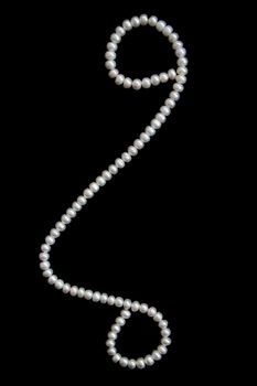 White pearls on the black velvet background 