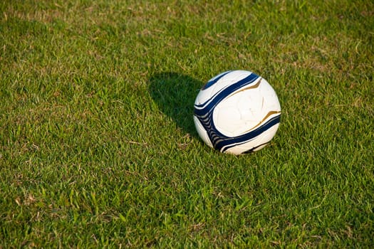 Soccer ball or football ball on green field