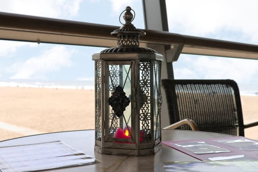 A candle in a decorative candlestick at the beach cafe. Den Haag. Netherlands.