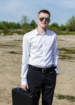 Businessman in glasses with a suitcase in his hand