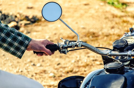 Man's hand rests on the steering wheel motorcycle