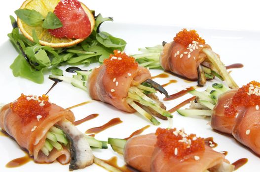 Fish rolls with herbs and fruit on a plate