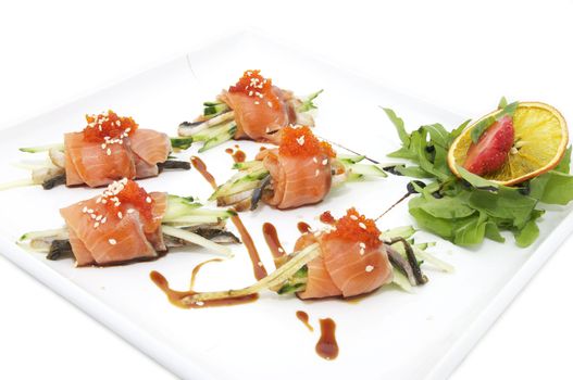 Fish rolls with herbs and fruit on a plate