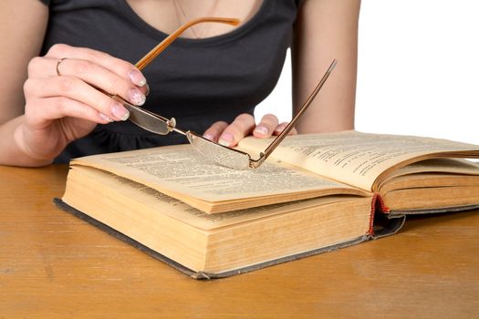 Hands of  girl with glasses over the opened book isolated on a white background