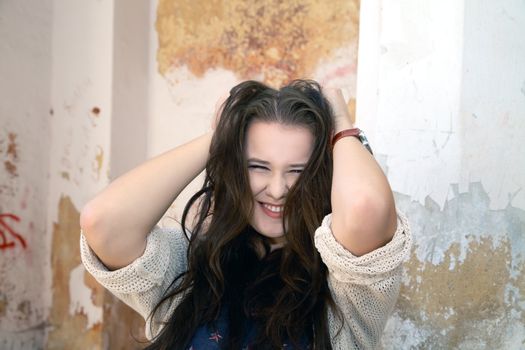 Beautiful plus size woman expresses delight against an old wall