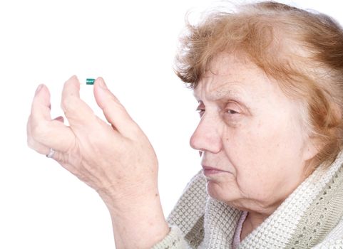 The old woman holds in hands  capsule with a medicine