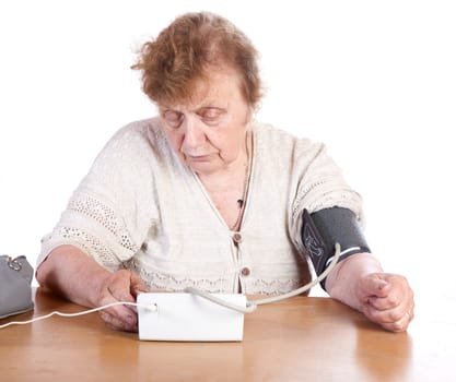 The old woman measures arterial pressure upon a white background