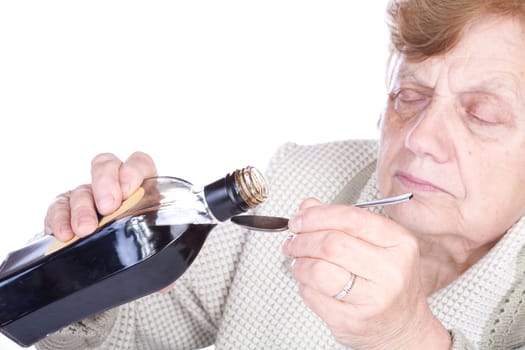 The old woman pours a liquid in the spoon