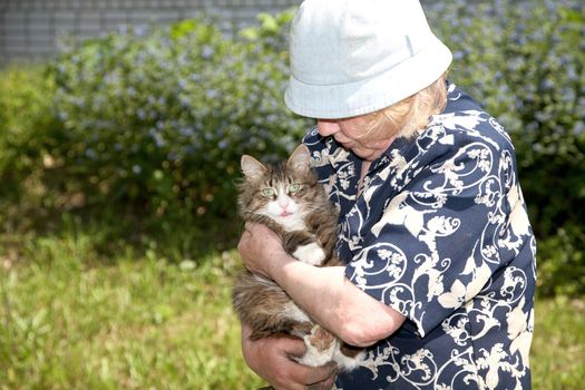 The old woman holds cat on hands
