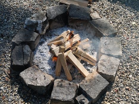 Campfire pit burning logs and sending sparks into the air.