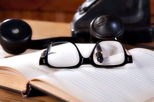 The old daily log with glasses and phone on a table