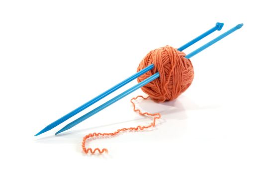 Balls of a yarn knitting spokes on white background