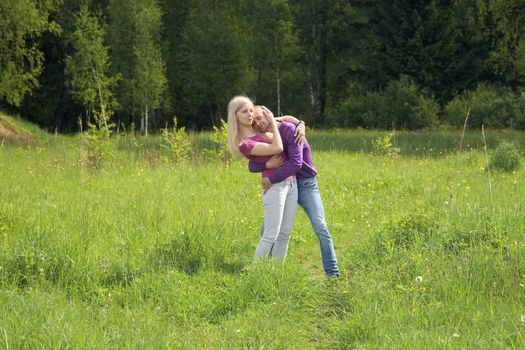 Embracing pair on a meadow in the spring afternoon