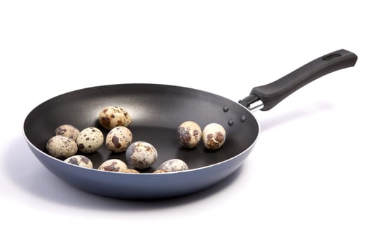 Frying pan with quail eggs on a white background
