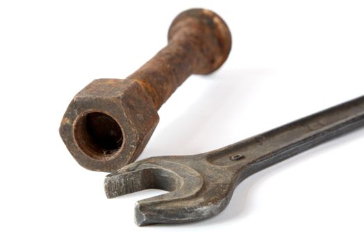 Wrench and rusty bolt with nut on a white background