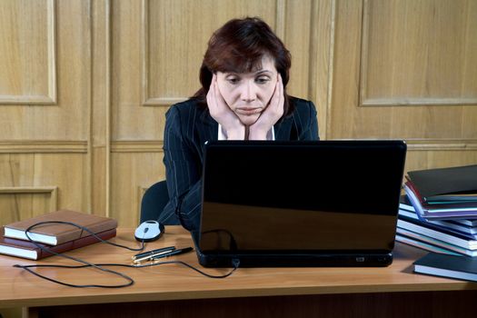  business woman thoughtfully looks at the laptop in an office