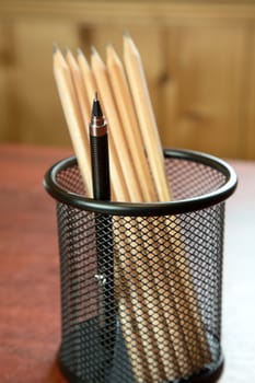 Mechanical pencil among wooden in a support on  desk