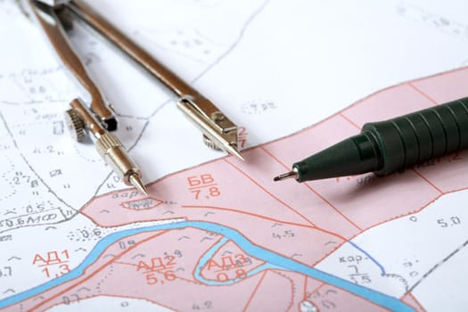 Topographic map of district with  measuring instrument,  ruler and a pencil