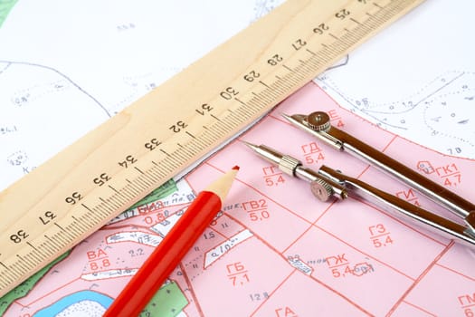 Red pencil  compasses and  ruler on a topographic map