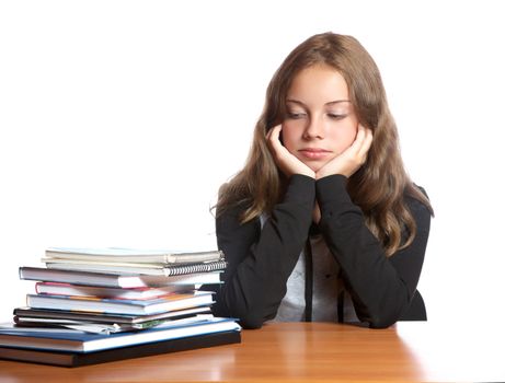 The girl-teenager looks at  pile of books on a white background