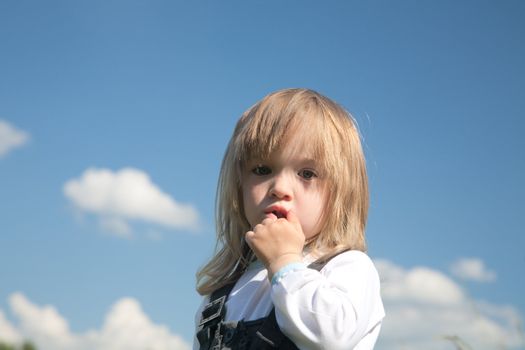  little girl on a background of the blue sky