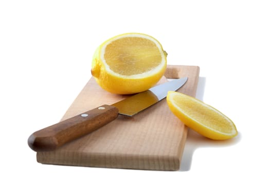 Knife and the cut lemon on a chopping board isolated