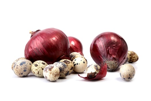 Red onions and quail eggs on a white background