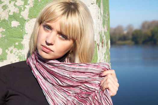 girl the blonde close up on river bank in the afternoon