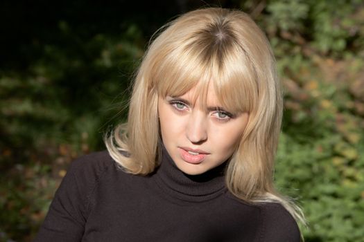 girl the blonde in  sunny day against a grass