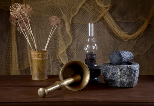 Still-life with mortars and an oil lamp on an old table