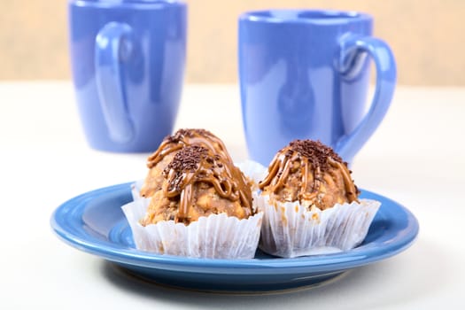 Cakes  plate and cups on a kitchen table
