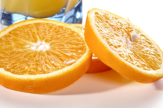 Segments of an orange and a glass of juice on a white background