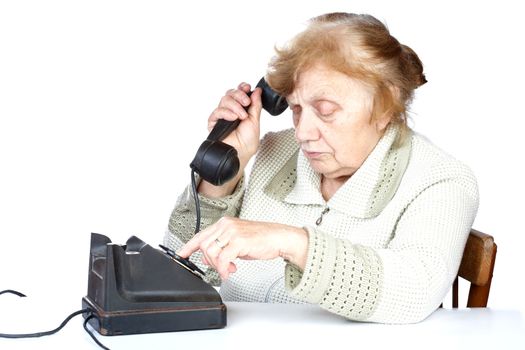 The old woman dials  number of phone on a white background
