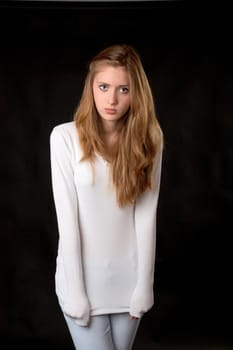 The girl in  white sweater on a black background