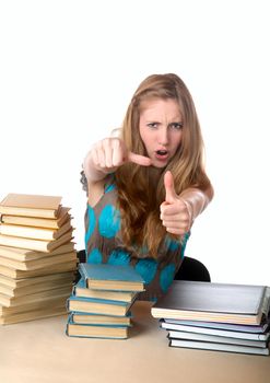 The girl-teenager against books shows a thumb