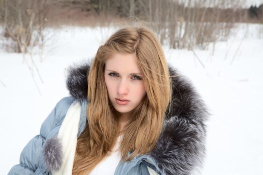 The beautiful girl against tree in the winter afternoon 
