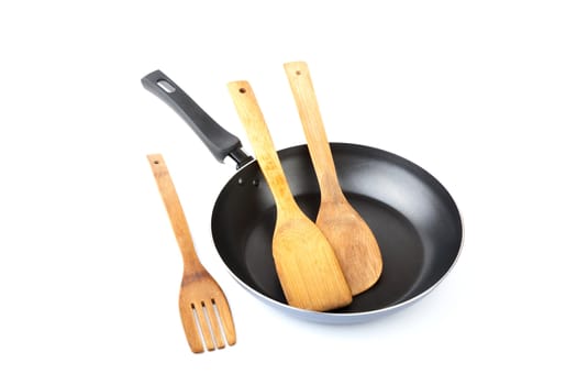 Wooden kitchen shovel in a frying pan on  white background