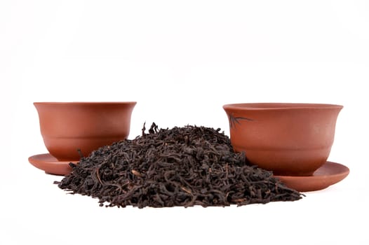 Cups and dry tea on a white background