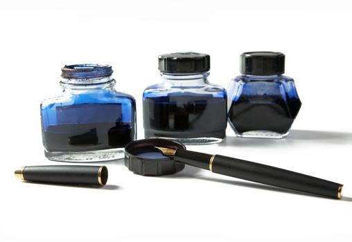 Small bottles with ink and  fountain pen on a white background